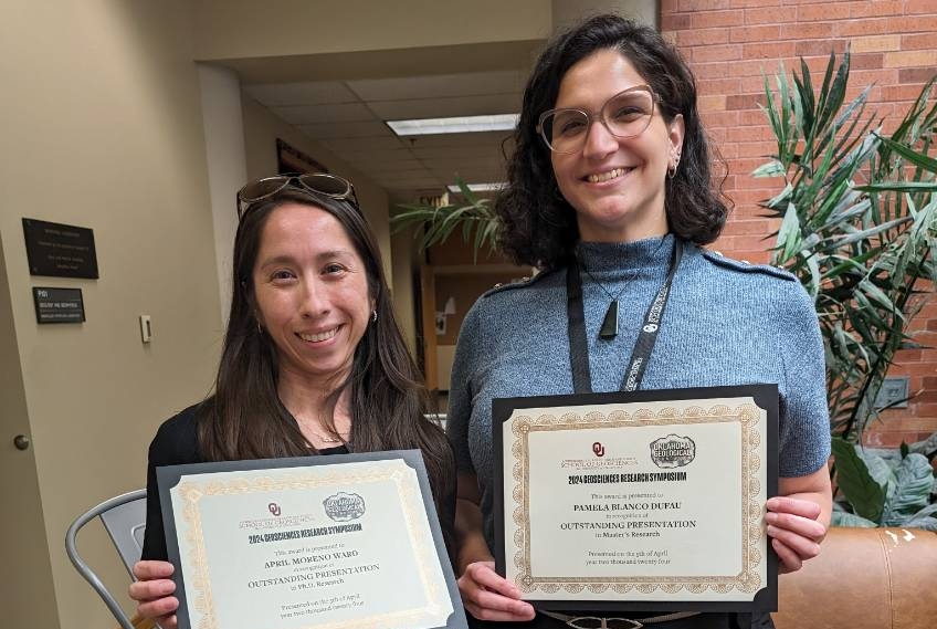 April and Pamela holding their award certificates.