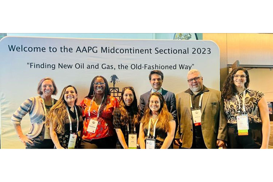 Dr Bedle and students stand in front of a AAPG MidCon poster.