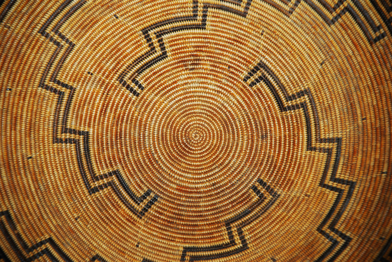 A Native American woven basket pattern, focus on center of spiral pattern.