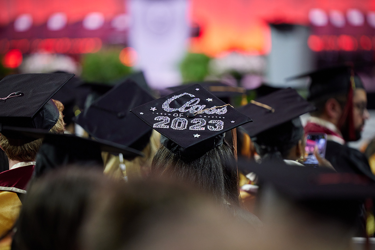 Graduation candidates at OU commencement ceremony, close up on a grad with a cap that says "Class of 2023"