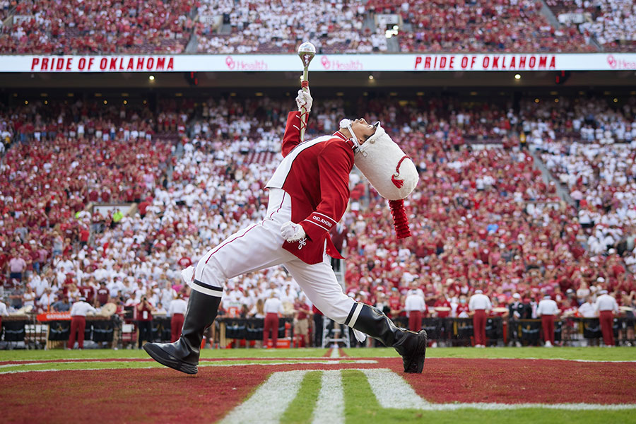 A drum major for the Pride of Oklahoma walking across the field.