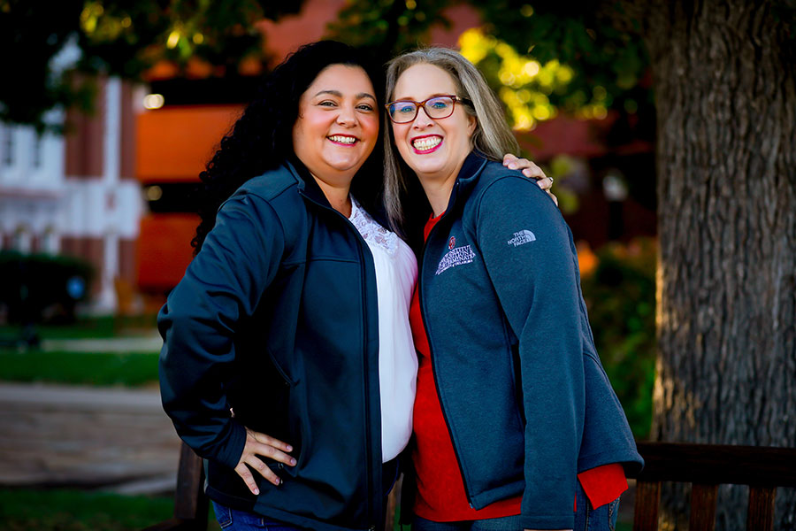 Two people standing together and smiling.