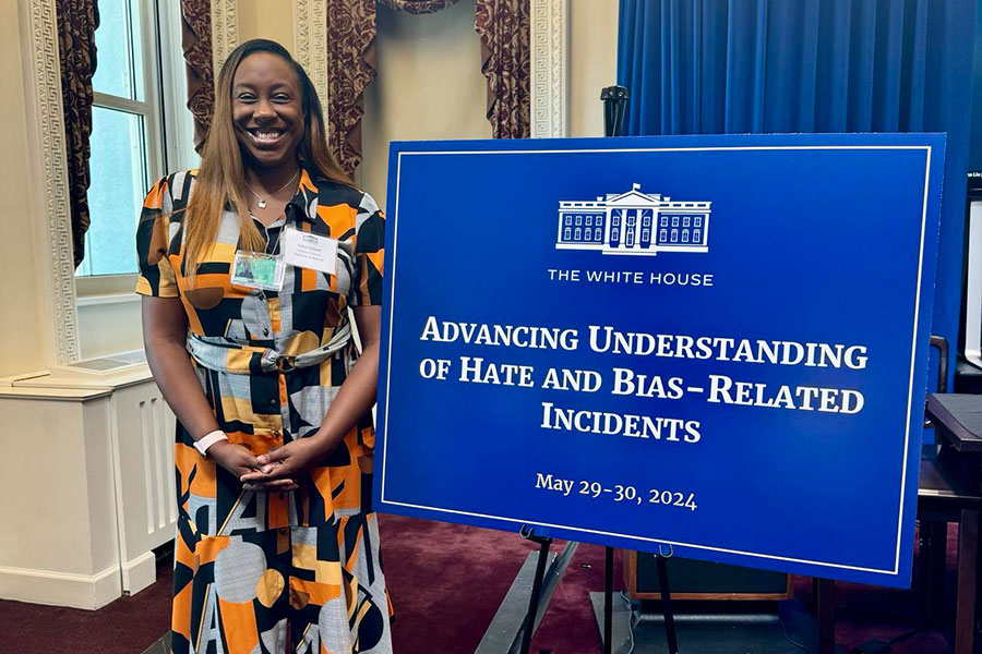 Kaleb Briscoe, Ph.D., at the White House next to a sign that reads "The White House, Advancing Understanding of Hate and Bias-Related Incidents, May 29-30, 2024."