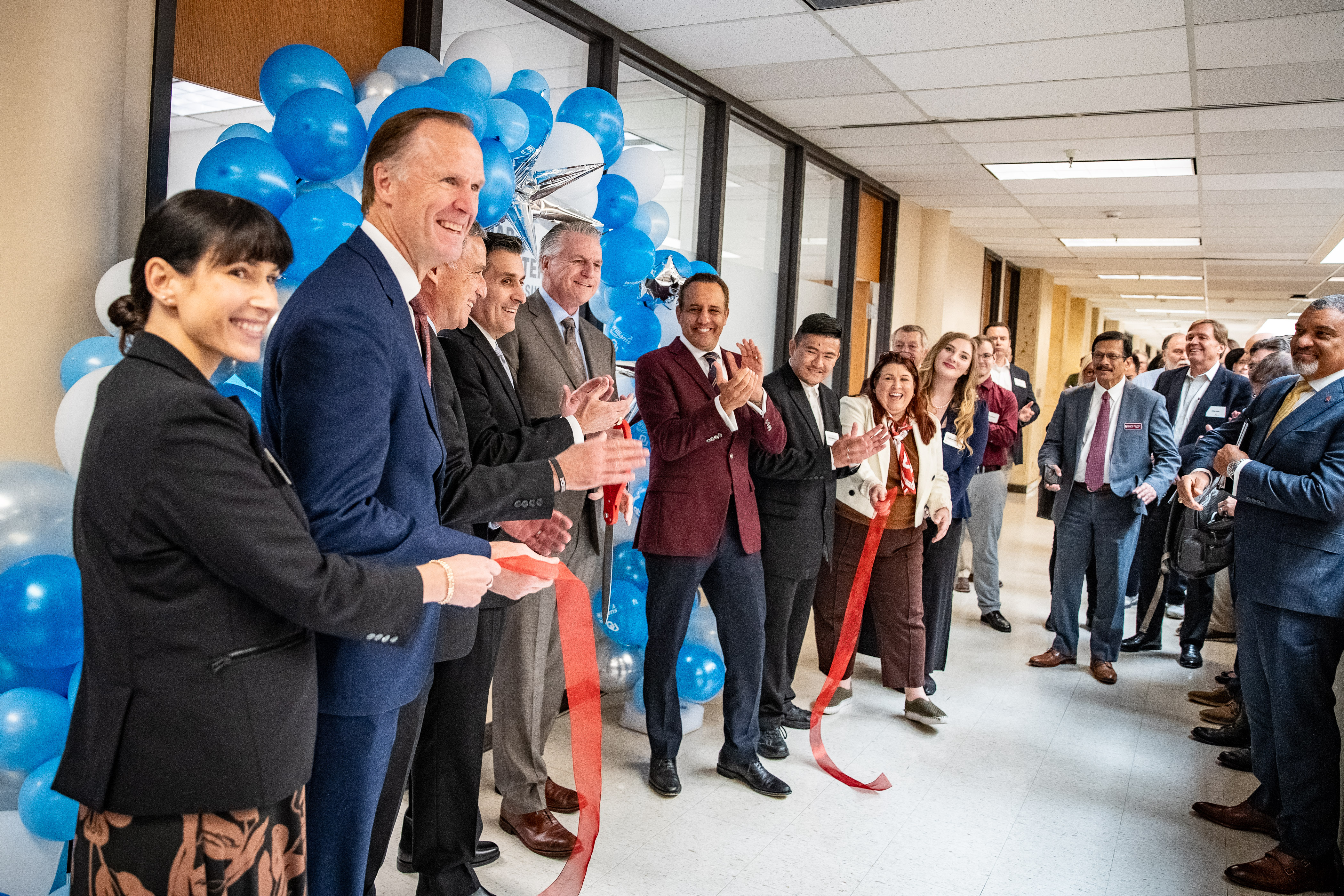 Those in attendance outside the new suite clap following the ribbon cutting. 