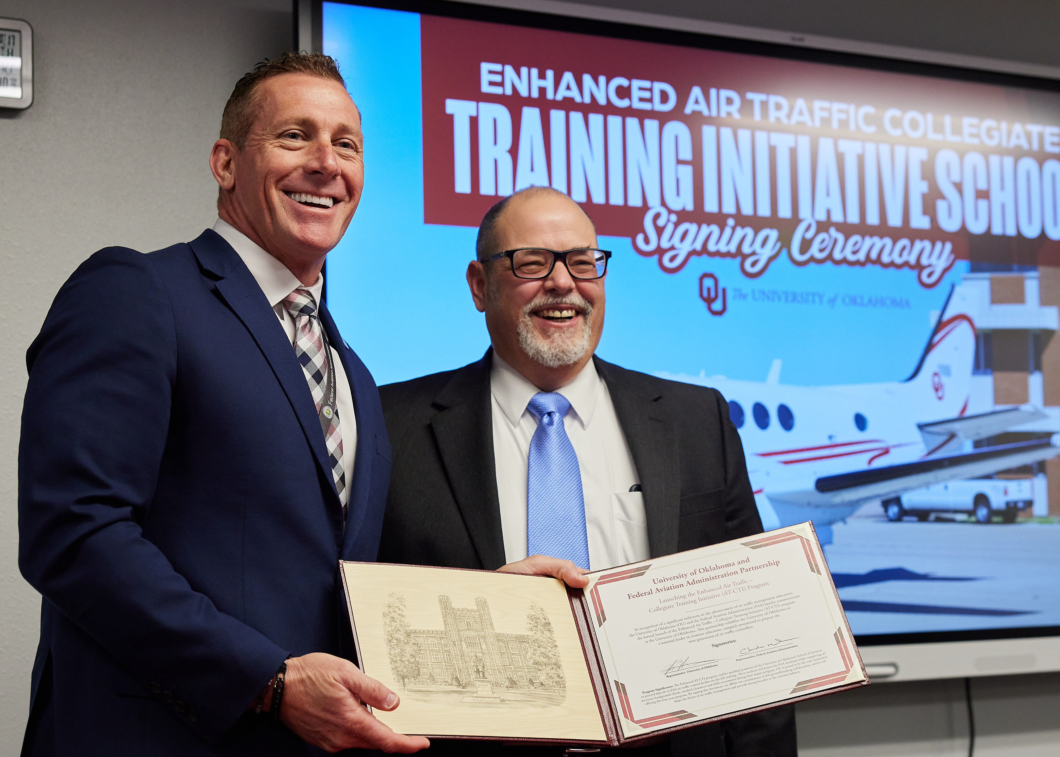 Chris Wilbanks and Mark Morvant holding the ceremonial signing document.