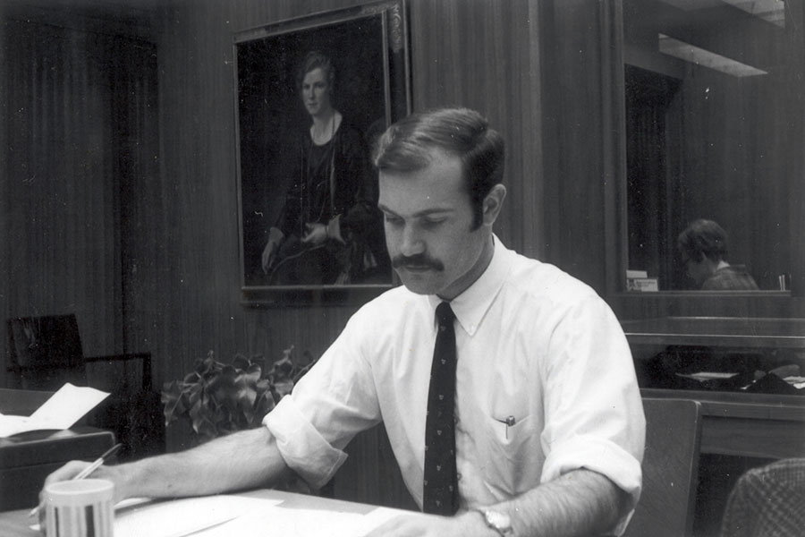 A young Kenneth Taylor sitting at a desk.