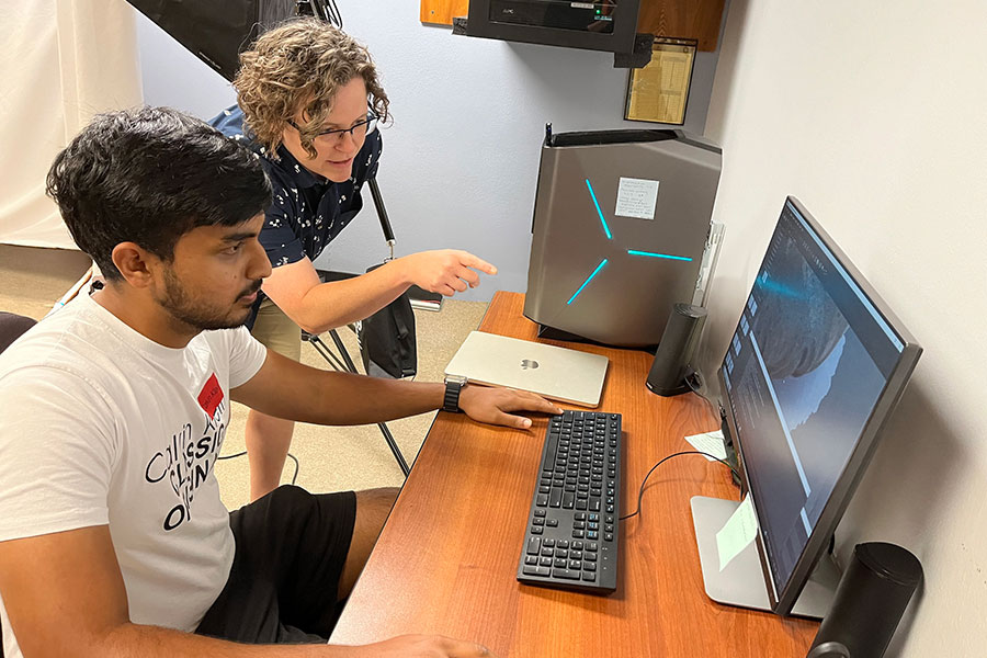 Two people doing archival work at a computer.