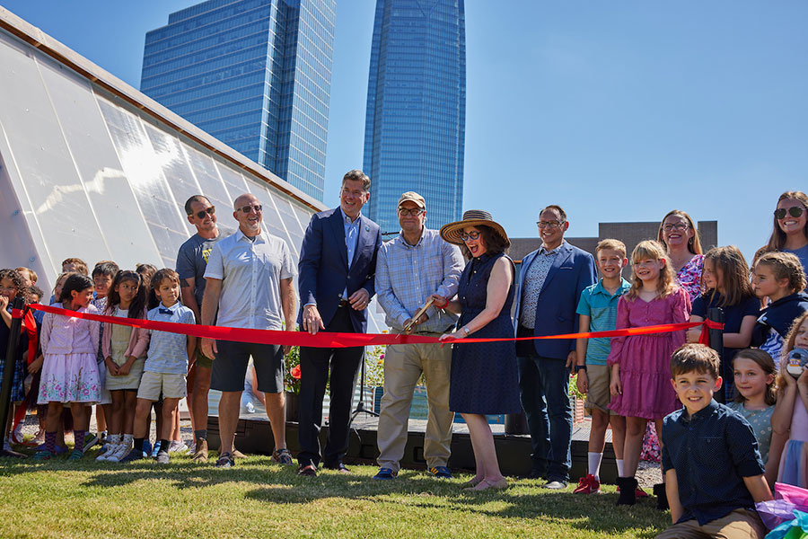 A group of people about to cut a ribbon.