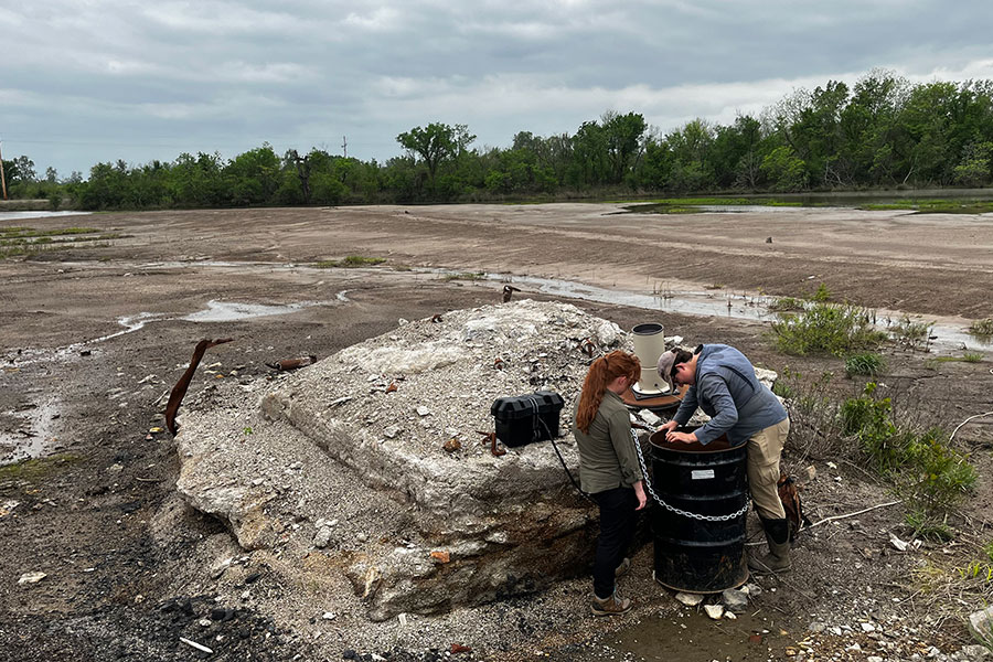 Two researchers stand in front of recovered iron oxide mine drainage residuals. 