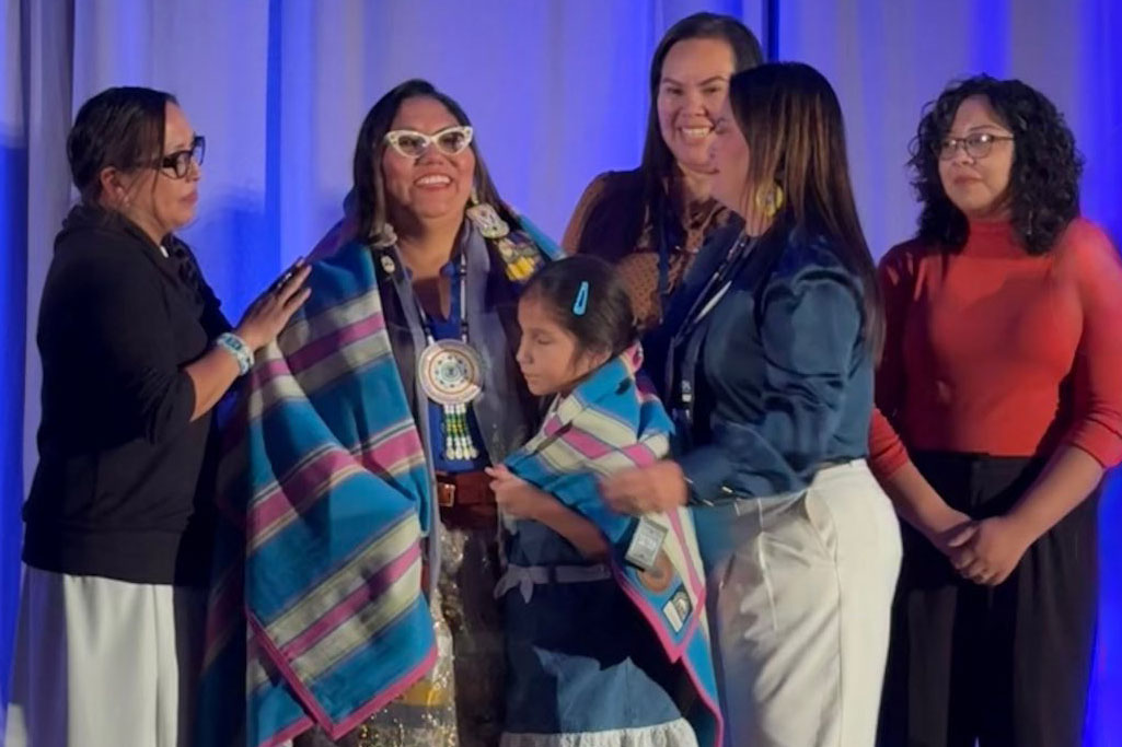 A group of people standing in front of a blue curtain.