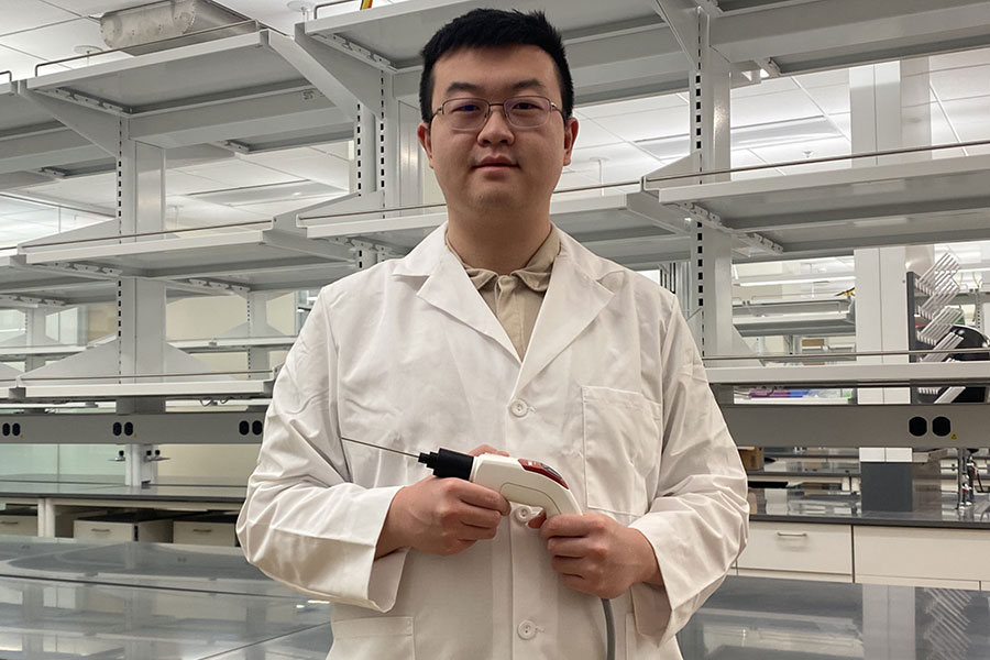 Chen Wang holding the optical coherence tomography probe.