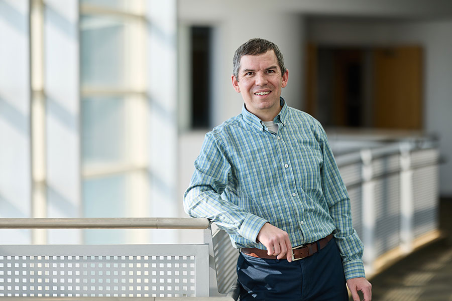 OU researcher Scott Salesky stands next to guardrail.