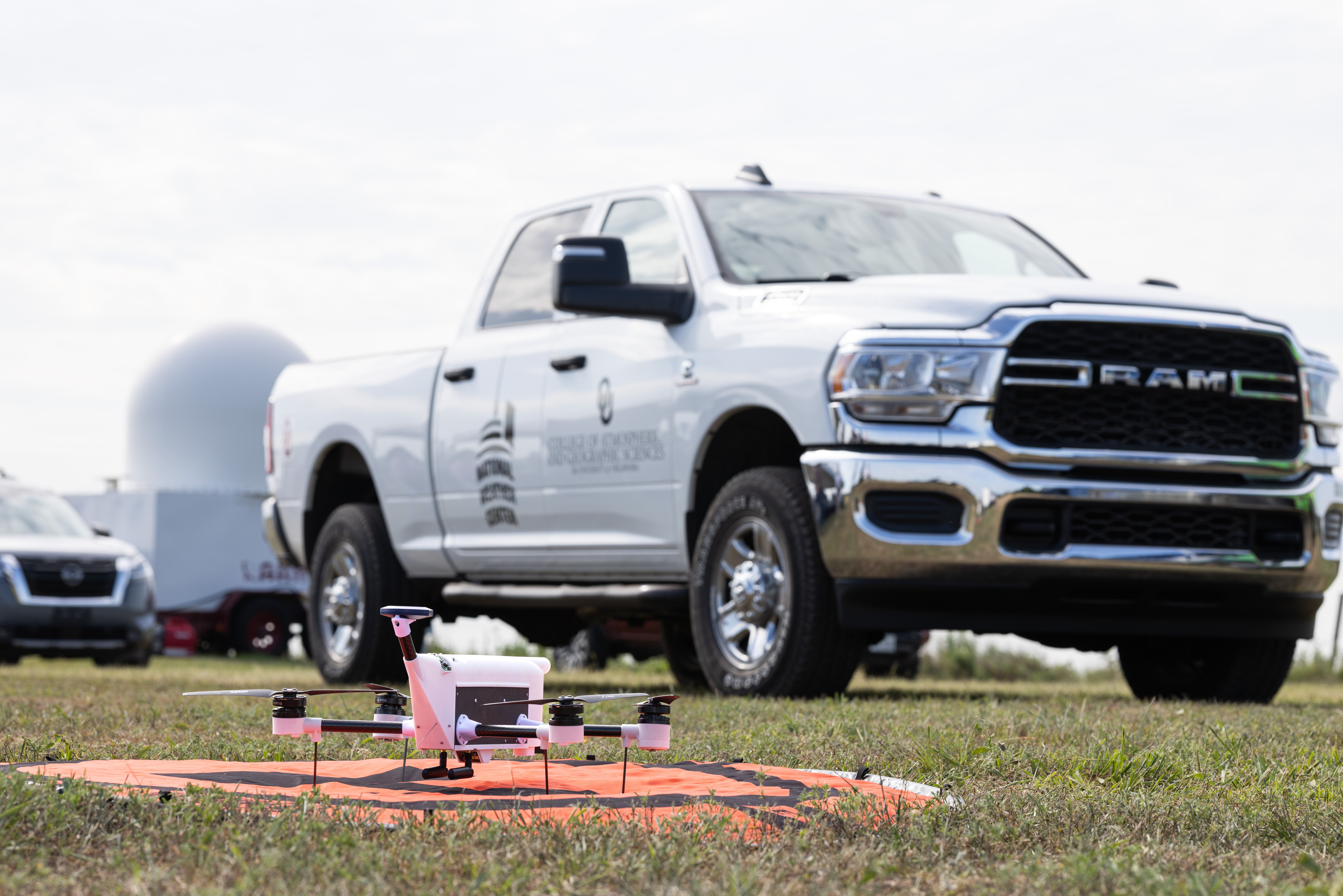 A drone sitting on a pad in front of a truck.