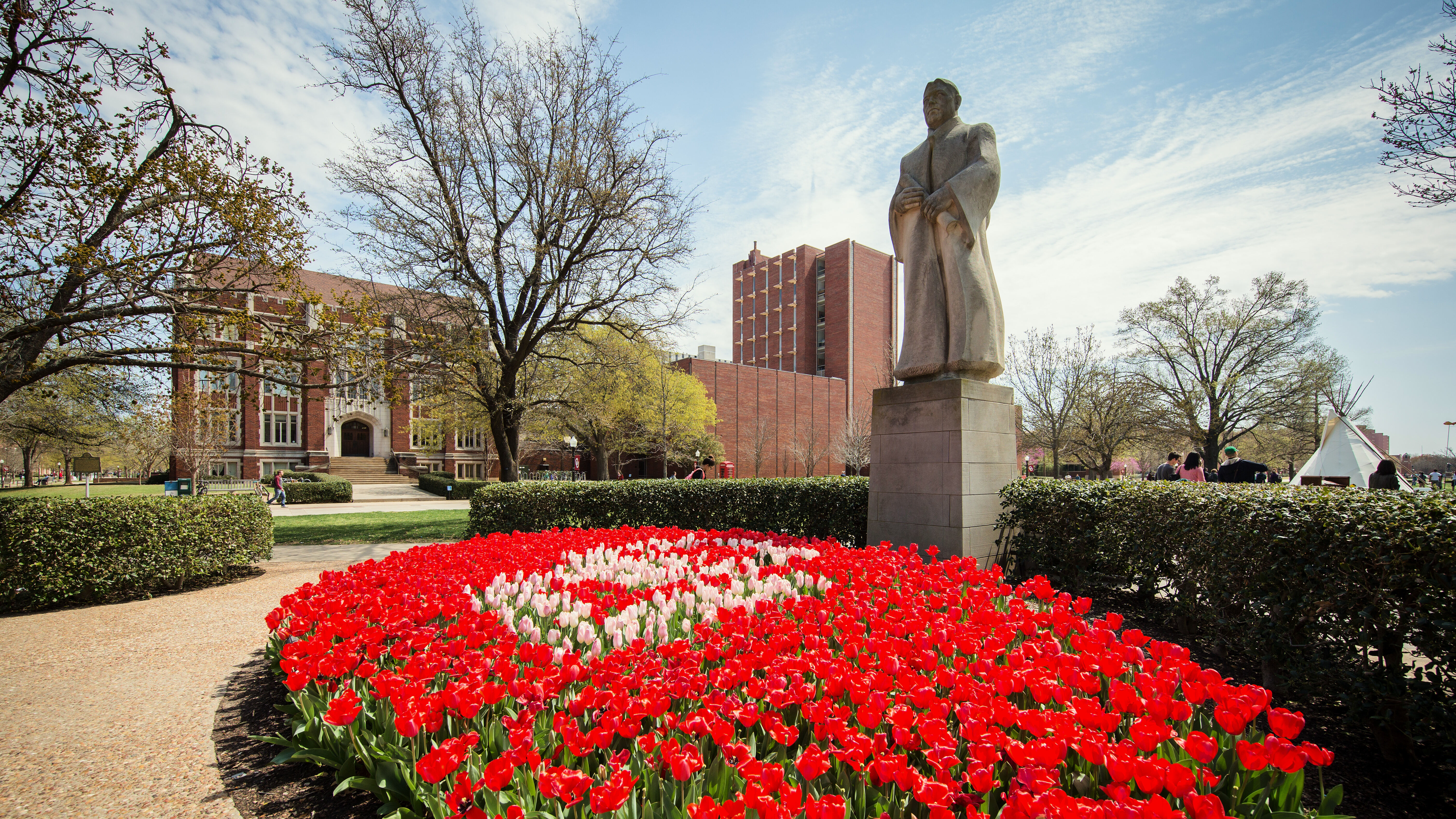 Tulips in front of a statue. 