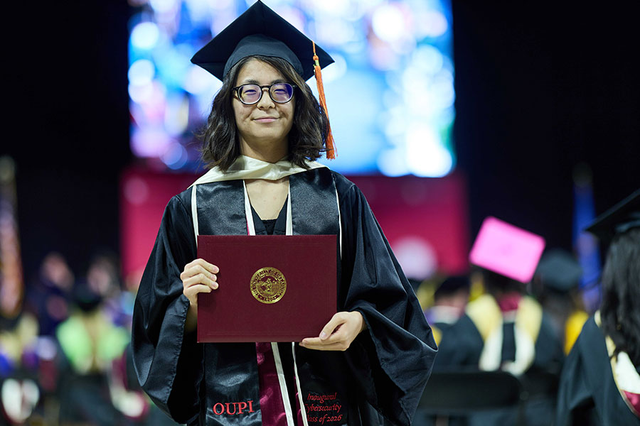 A graduate holding a diploma cover.