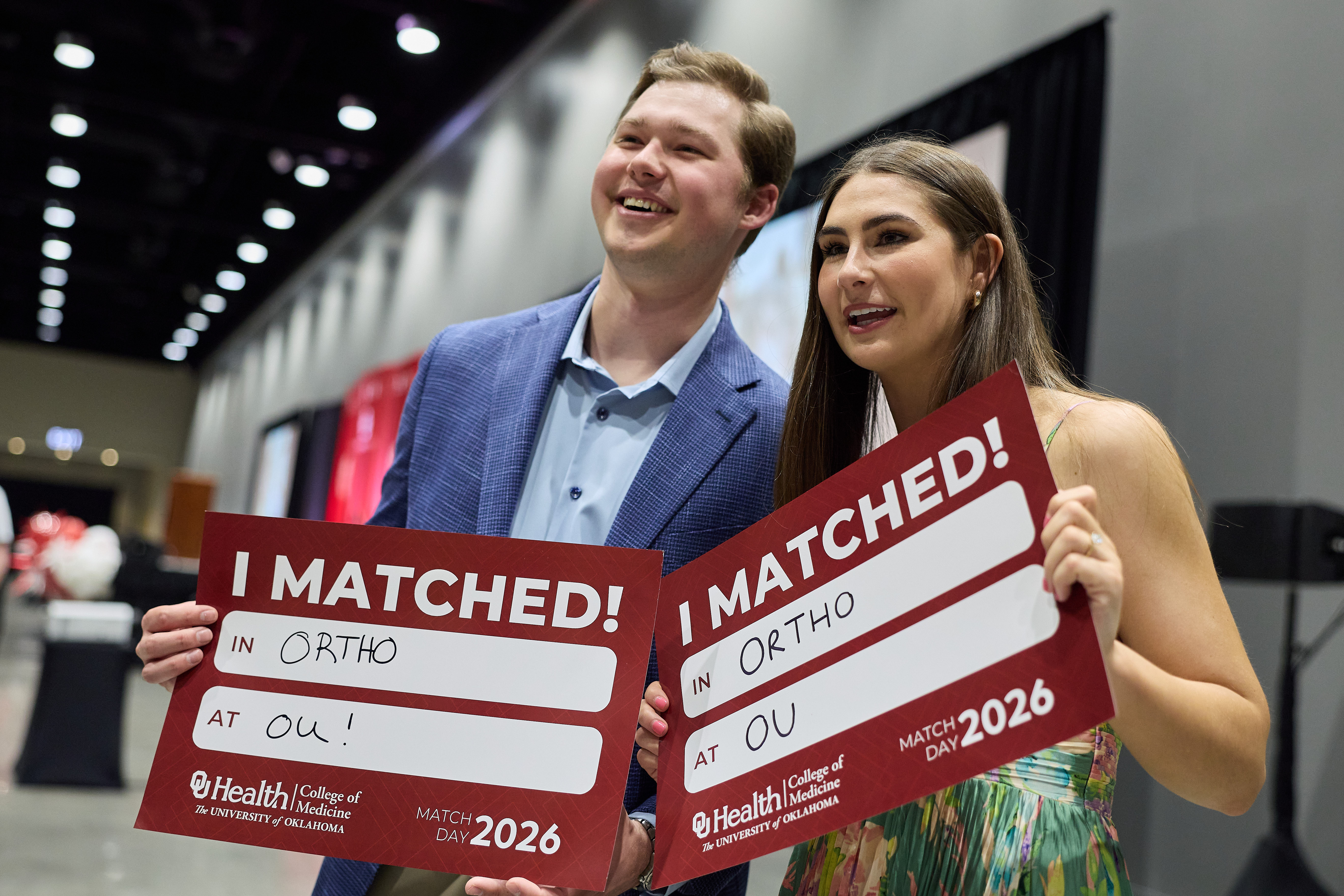 Two students holding up signs that say "I Matched in Ortho at OU."