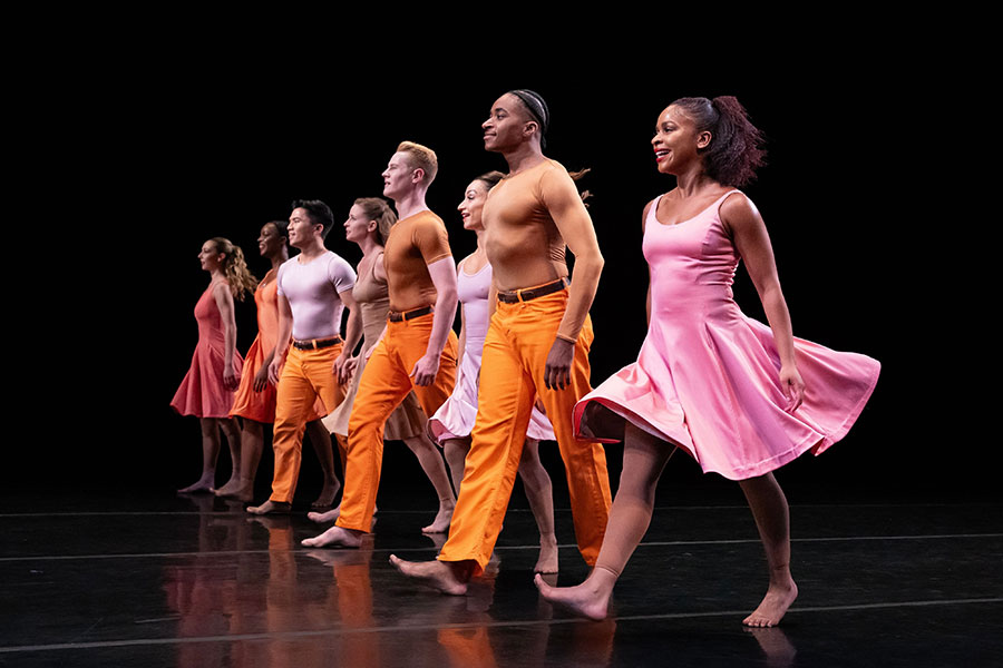 A group of dancers moving downstage.
