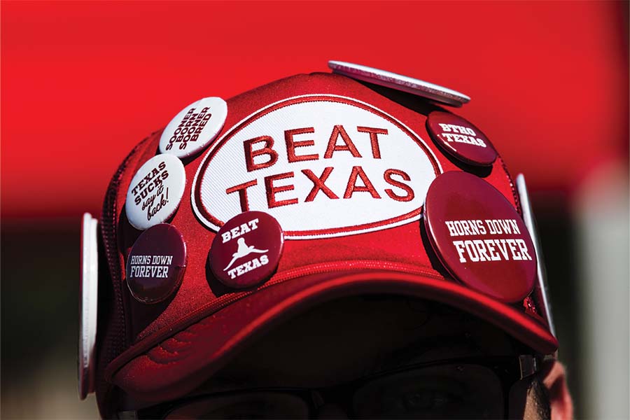A fan's hat with pins and a patch that says "Beat Texas"