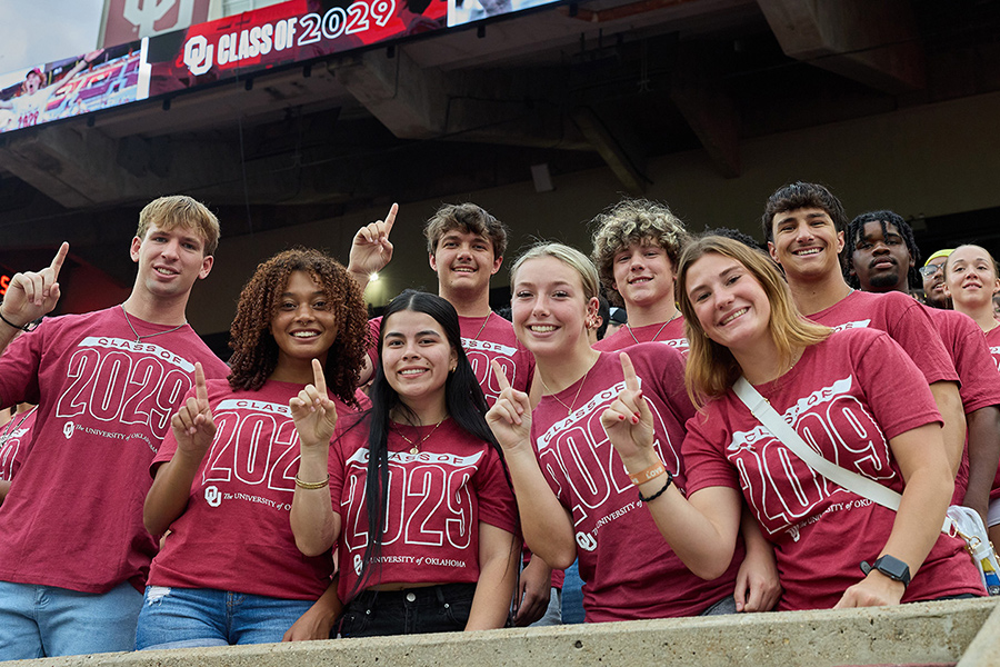 New OU class of 2025 students together in the stadium, holding up the "there's only one" hand sign.