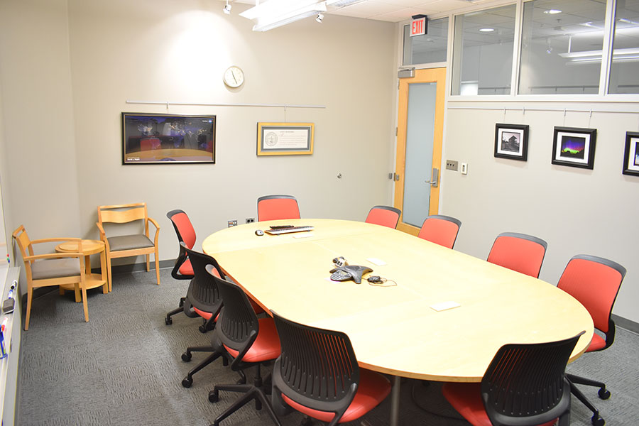 The Dean's Office Boardroom, with a large table and several chairs in the center.