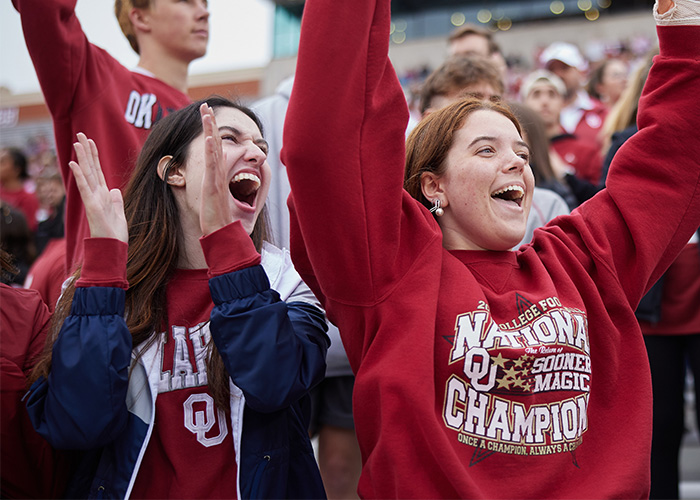 Sooner fans wearing OU sweatshirts at a sporting event