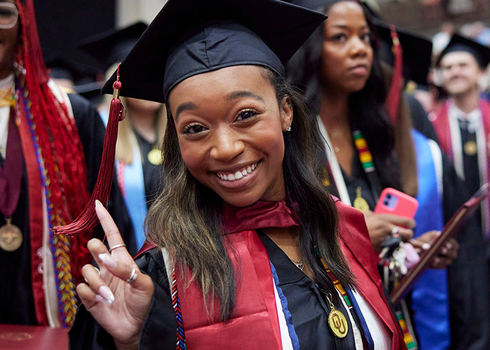 smiling OU graduate celebrating during college graduation ceremony