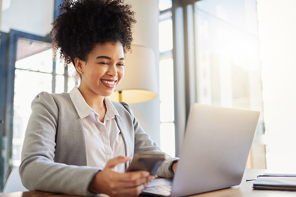 Smiling woman looking at a laptop.