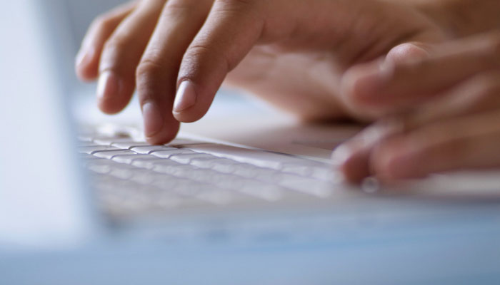 close up on hands on laptop keyboard