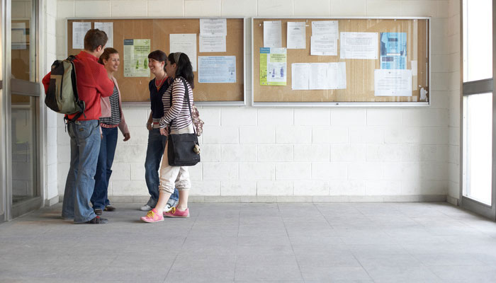 4 students standing in front of an information board