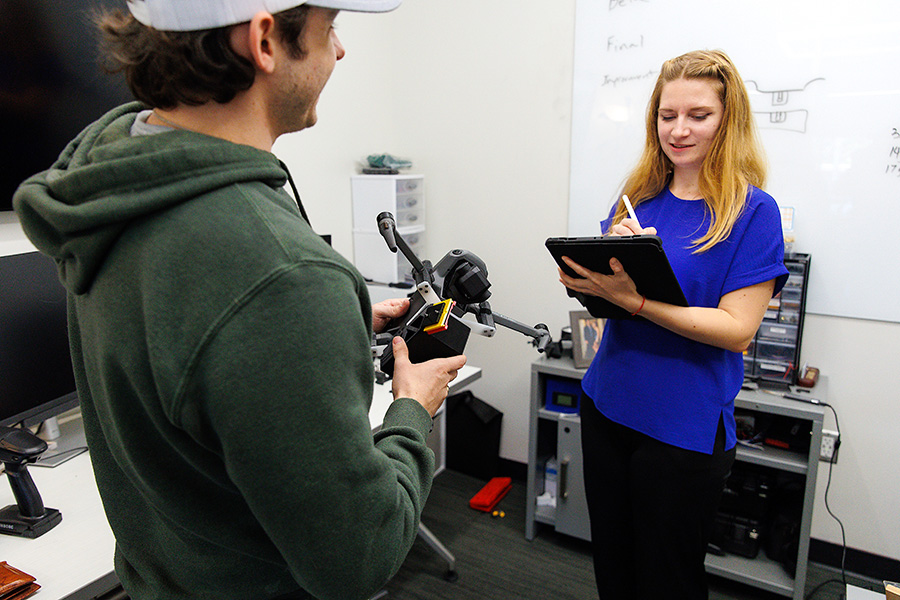 Two people working together with a drone, tablet and other technoloy.