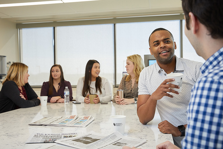 A group of MBA students working together in a small collaborative group.