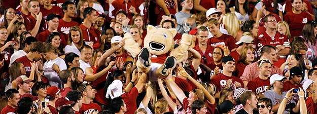 O U mascot is being held up by fans at a football game