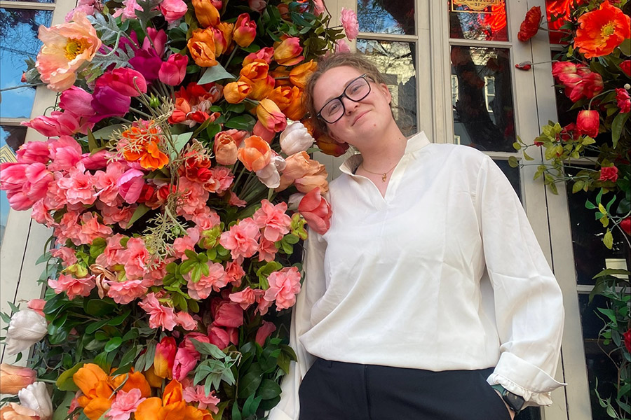 Emily Rose Williams standing in a doorway flanked with roses.