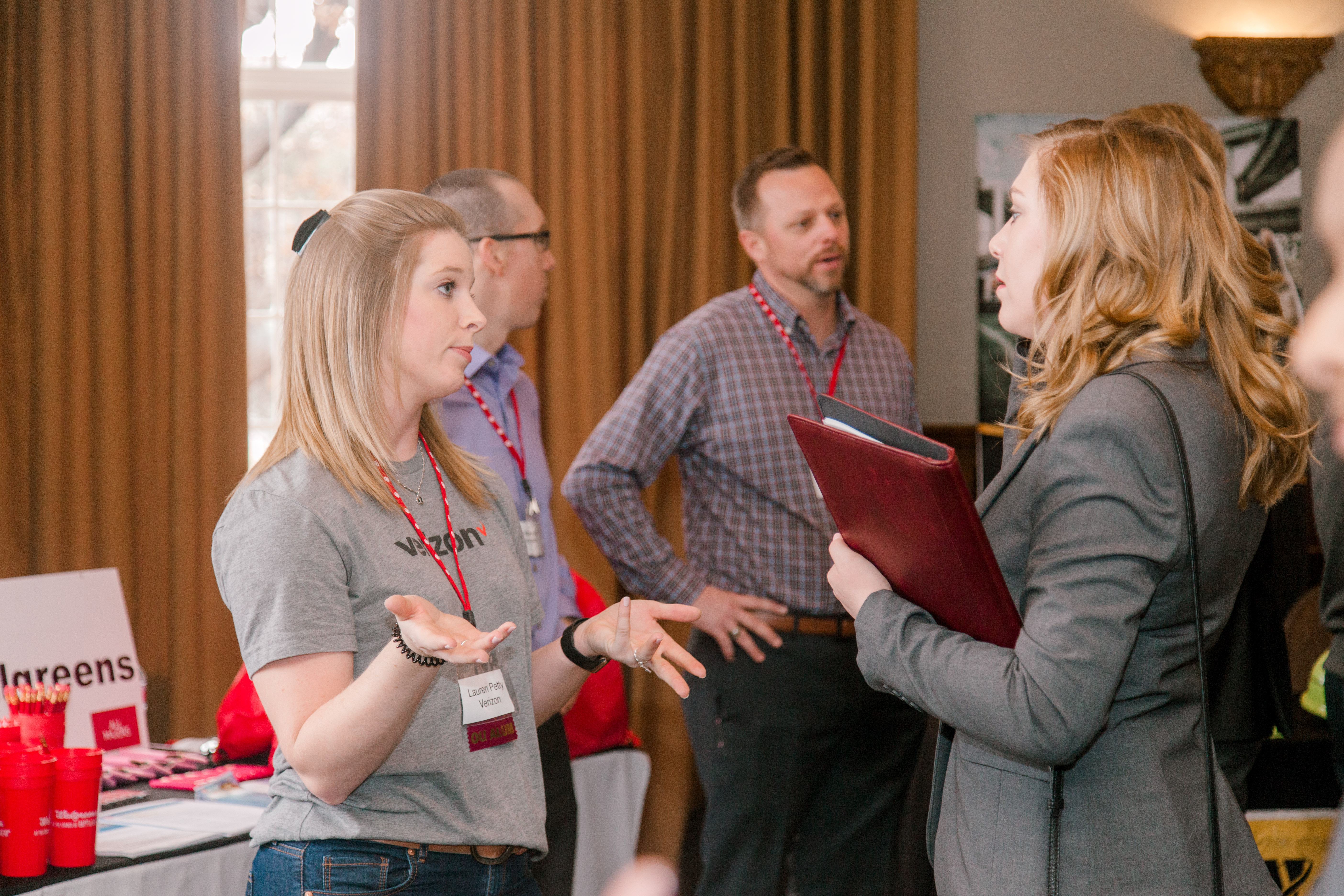 A career coach talking to a student at a career fair. 