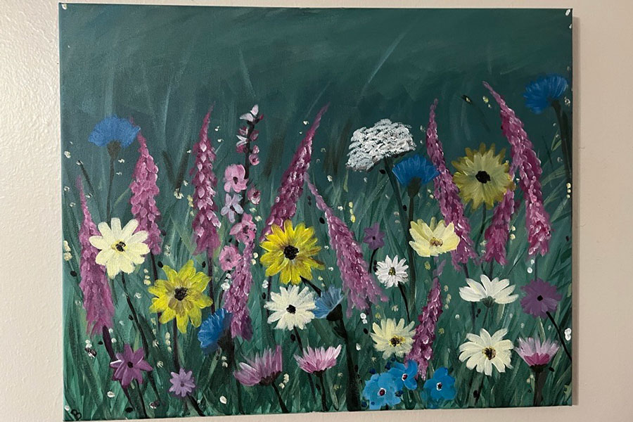 A painting of bright wildflowers in purples, blues, whites, and yellows framed by a deep green background.