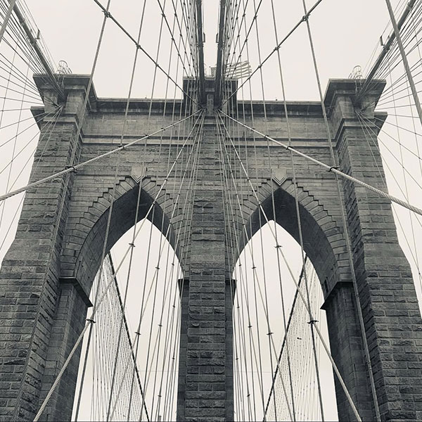 A black and white image of a brick and steel bridge.