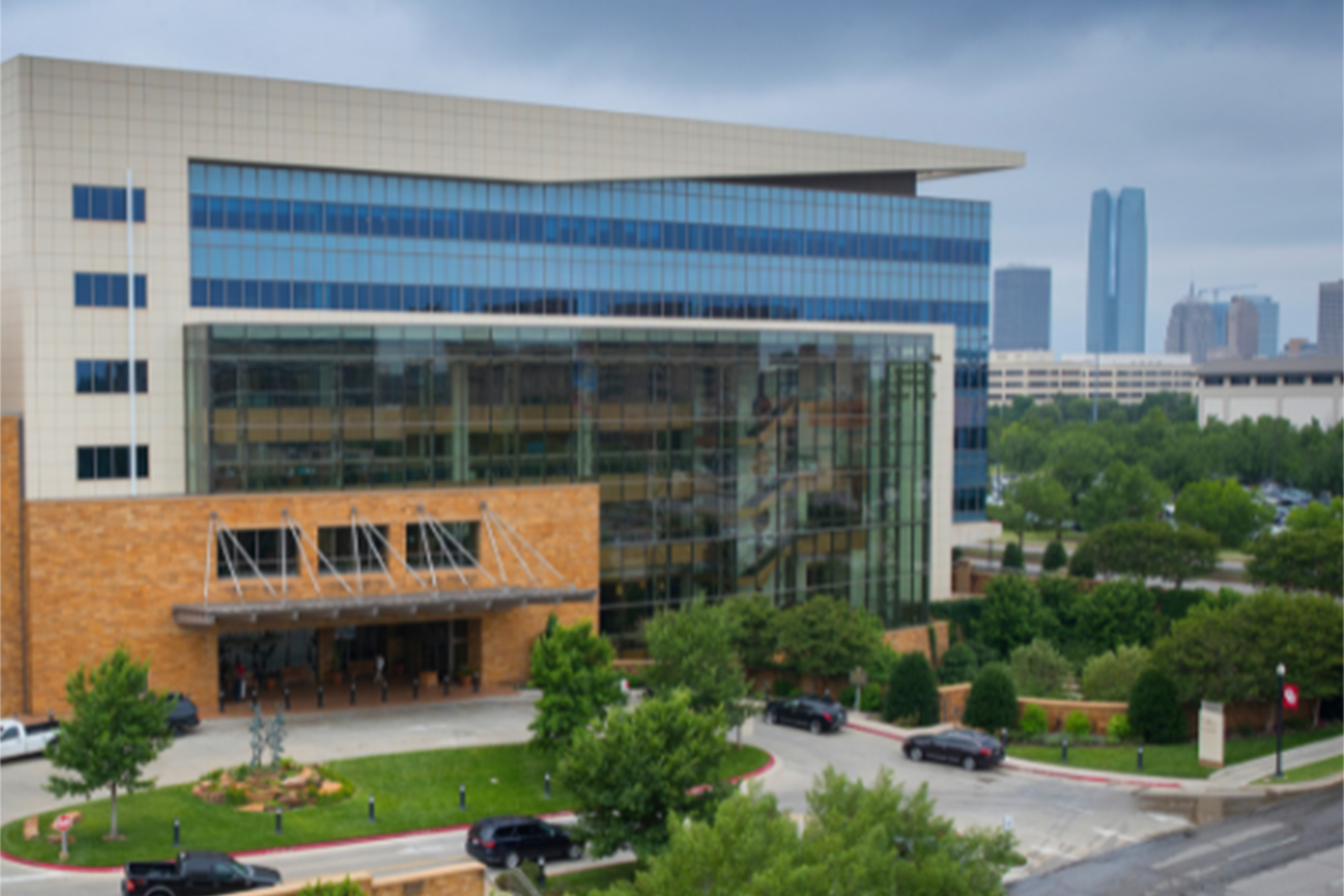 A wide shot of the Health Campus Student Union with the OKC skyline behind it. 