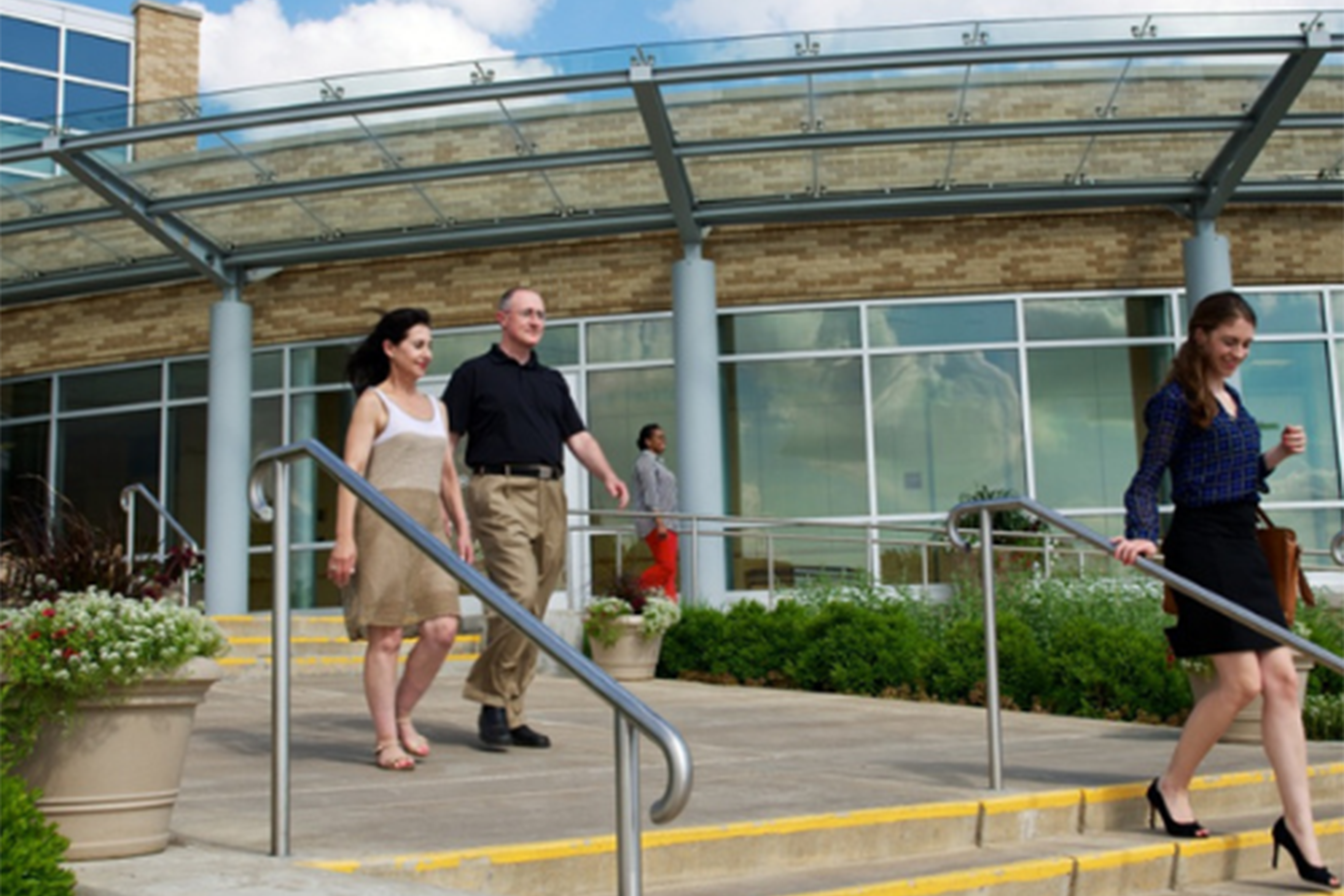 A shot of students and staff walking down stairs in front of the OU Tulsa campus.