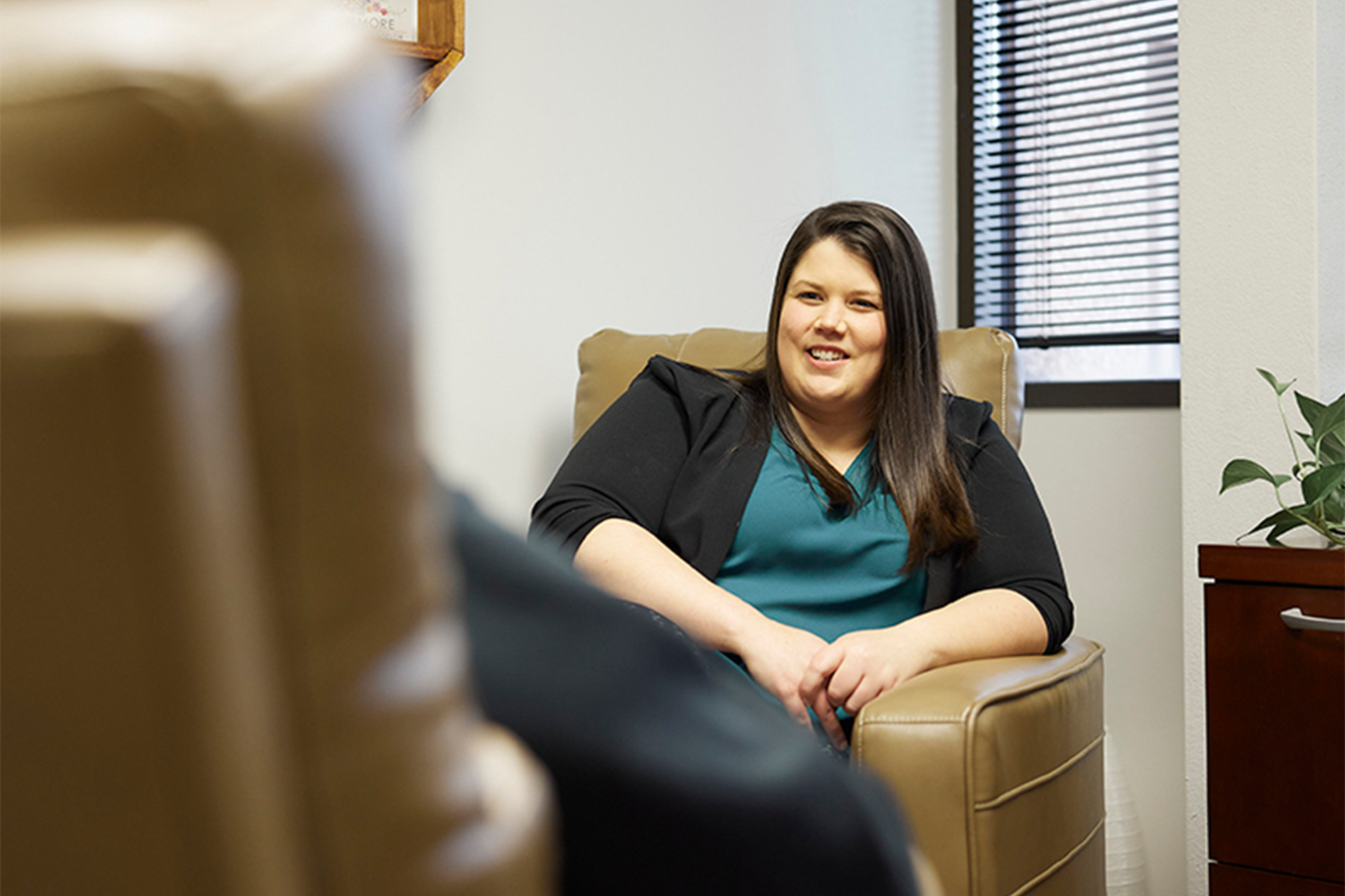 A shot of a therapist counseling an unknown person sitting in cozy chairs.
