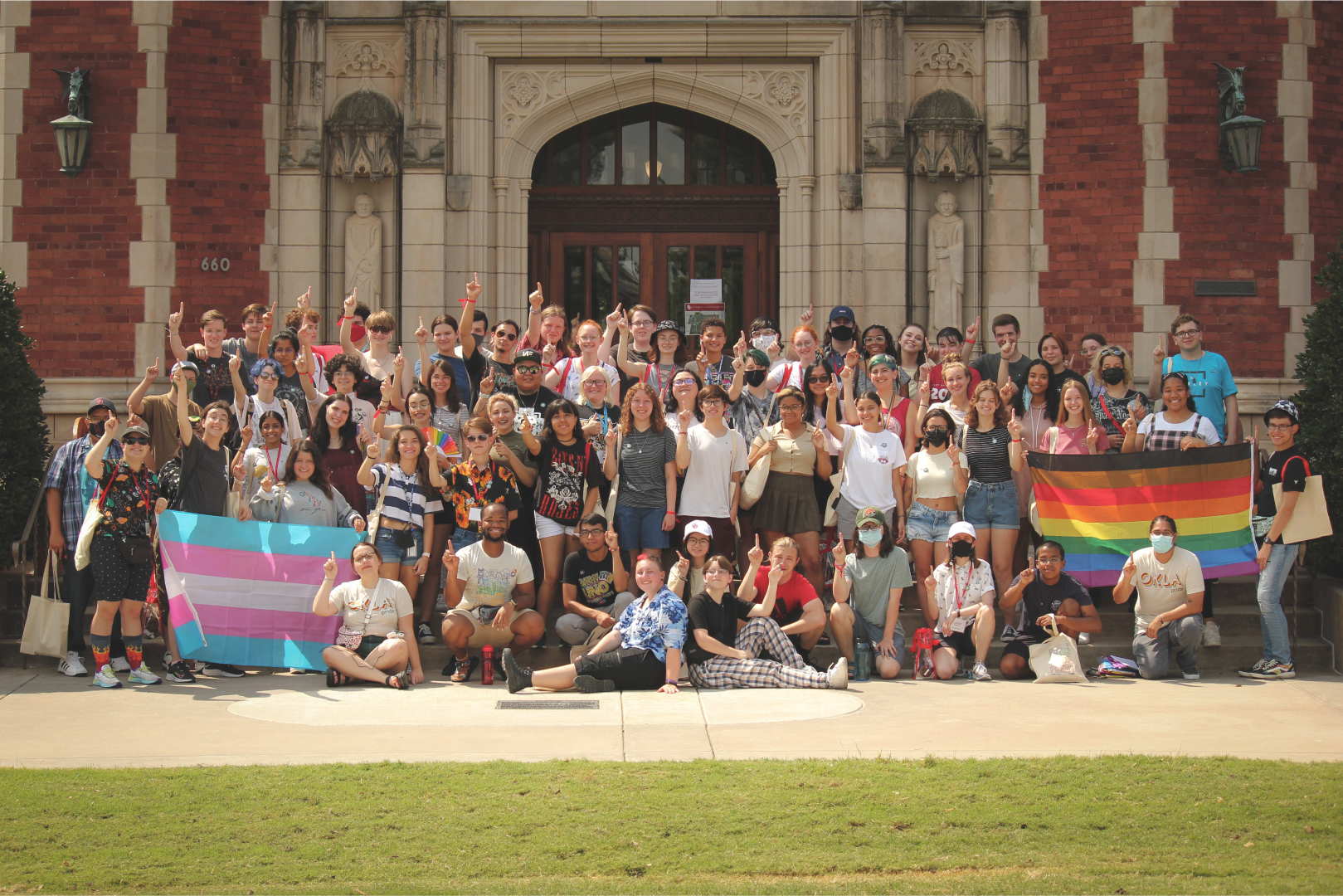 A picture of a group of students holding Pride flags in front of Evans