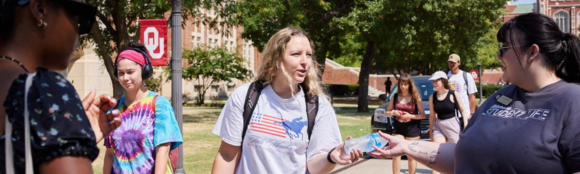 A Student Life staff member handing a student a bottle of water.