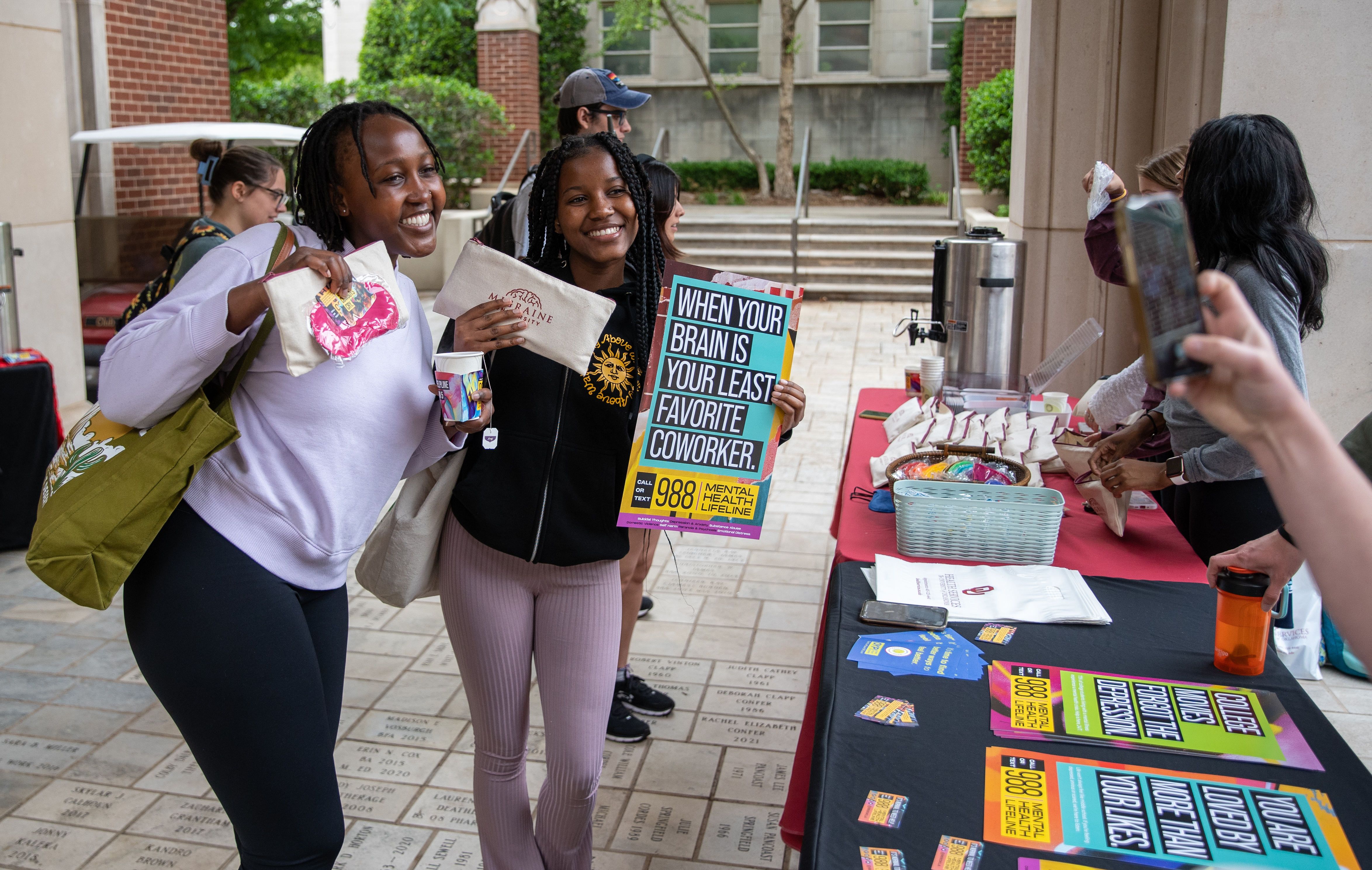 Two students holding a 988 poster at an outreach event.