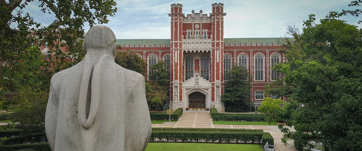 Photo of statue with Bizzell Library in the background