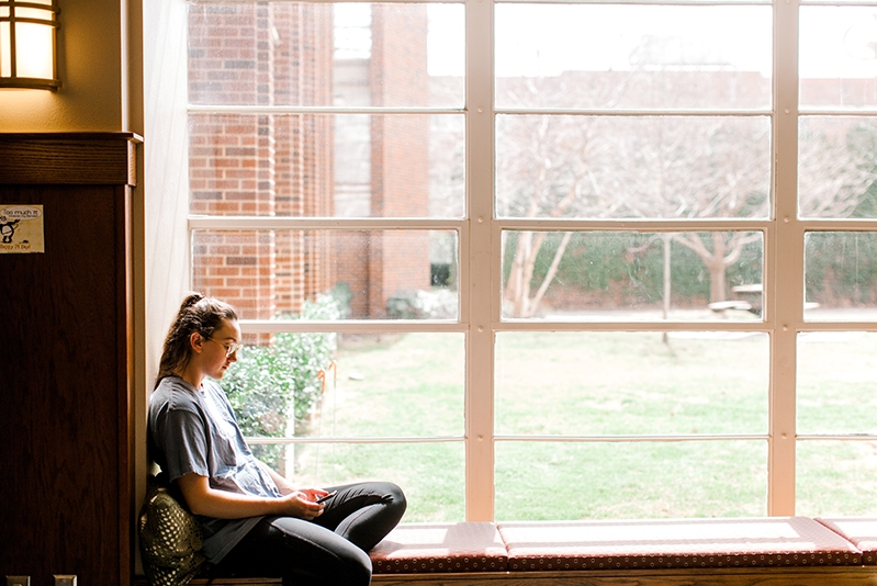Student sitting by the window in Collings Hall