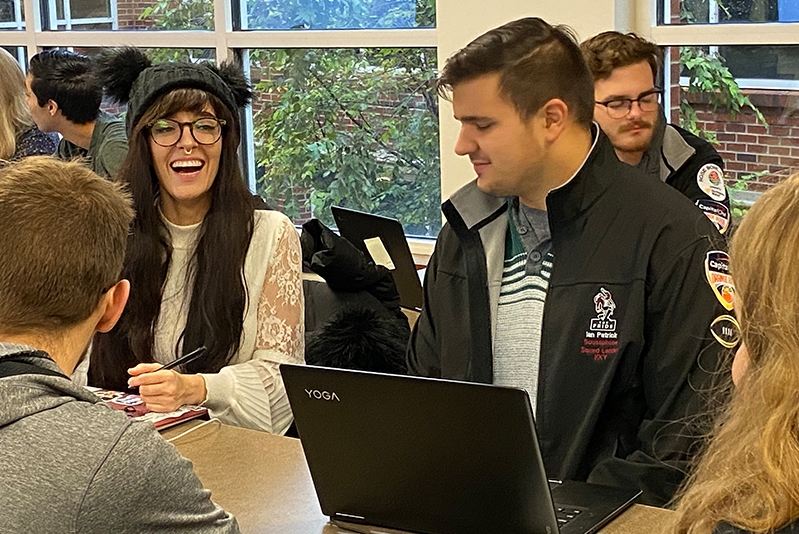 Students sitting at computers in class laughing