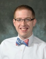 headshot of David Powell in a white shirt and bow tie