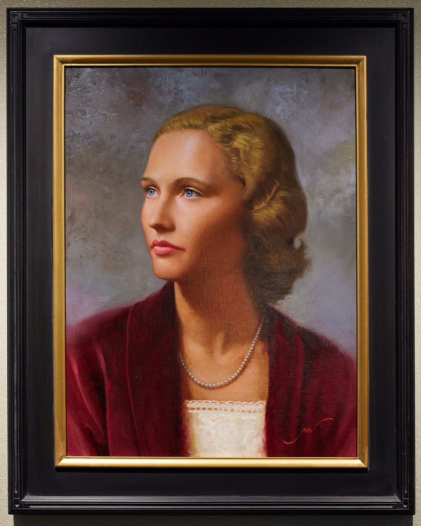 Portrait of a woman with blonde hair wearing a white shirt and red blazer