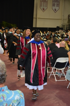 Sister Rosemary in cap and gown walking out of graduation
