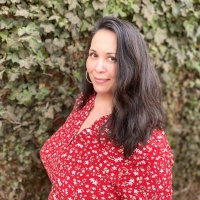 picture of Mirelsie Velazquz standing in front of an ivy wall