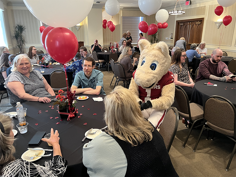 Boomer mascot sitting at a table full of people